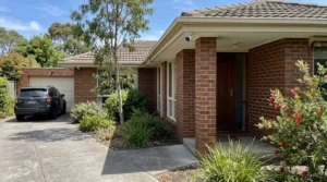 Two outdoor security cameras mounted under the eaves of a Melbourne house covering the driveway and front door